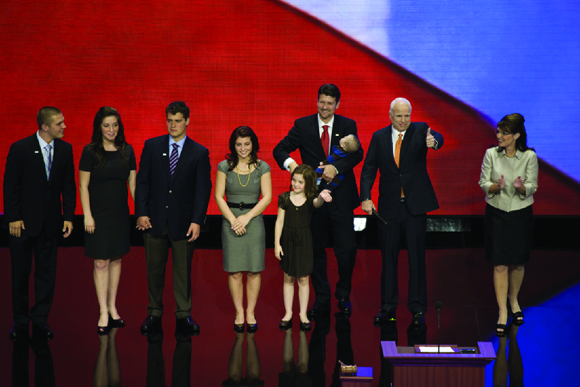 An image of Sarah Palin on a stage with John McCain and several other people.