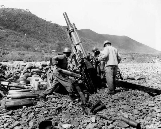 An image of several soldiers surrounding an artillery piece.